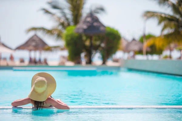 Young beautiful woman enjoying summer vacation in luxury swimming pool — Stock Photo, Image