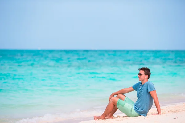 Giovane uomo godendo la musica sulla spiaggia bianca — Foto Stock