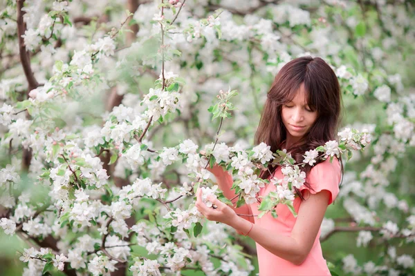 Девочка наслаждается запахом в весеннем вишневом саду — стоковое фото