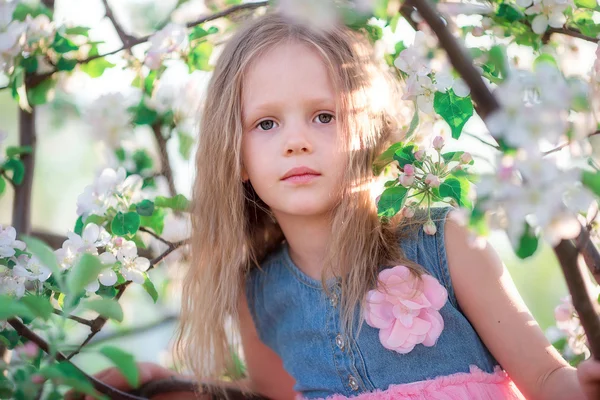 Porträtt av bedårande liten flicka i blommande körsbär träd trädgård utomhus — Stockfoto