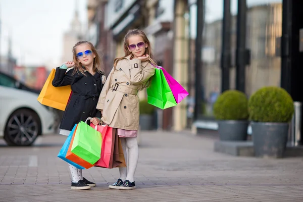 Entzückende kleine Mädchen mit Taschen beim Einkaufen im Freien — Stockfoto