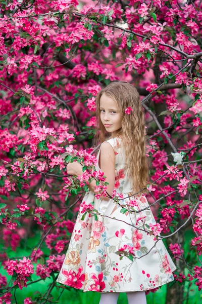 Entzückendes kleines Mädchen im blühenden Frühlingsapfelgarten im Freien — Stockfoto