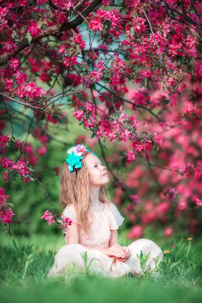 Adorable little girl in beautiful blooming apple garden outdoors — Stock Photo, Image