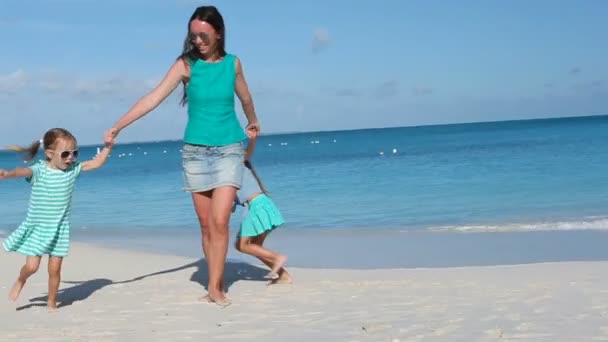 Família feliz com crianças pequenas se divertindo na praia exótica no dia ensolarado — Vídeo de Stock