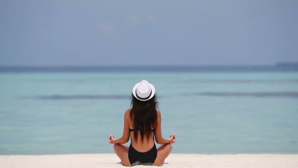Glücklich entspannte junge Frau praktiziert Yoga im Freien am weißen Strand — Stockvideo