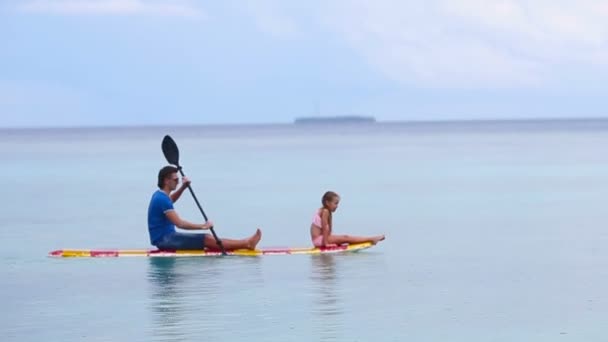 Sörf tahtası üzerinde küçük kız ve genç Baba — Stok video