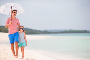 Mutlu aile beyaz tropik sahilde eğleniyor