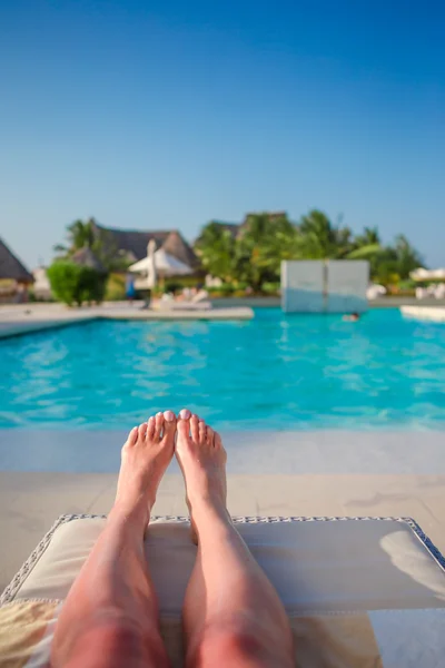 Pies femeninos al aire libre durante las vacaciones de verano. Mujer relajarse cerca de la piscina — Foto de Stock