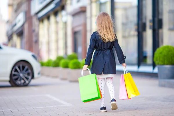 Rozkošná holčička se baví s nákupní tašky venku — Stock fotografie