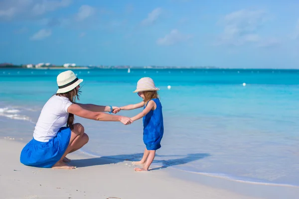Kleine meisje en jonge moeder op het strand — Stockfoto