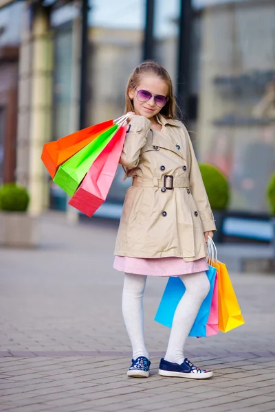 Sevimli küçük kız ile alışveriş torbaları açık havada yürüyüş — Stok fotoğraf