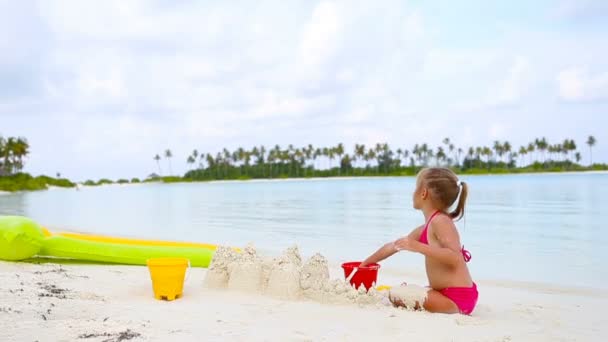 Klein meisje spelen met strand speelgoed tijdens tropische vakantie — Stockvideo