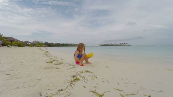 Entzückendes kleines Mädchen am weißen Strand während des Tropenurlaubs — Stockvideo