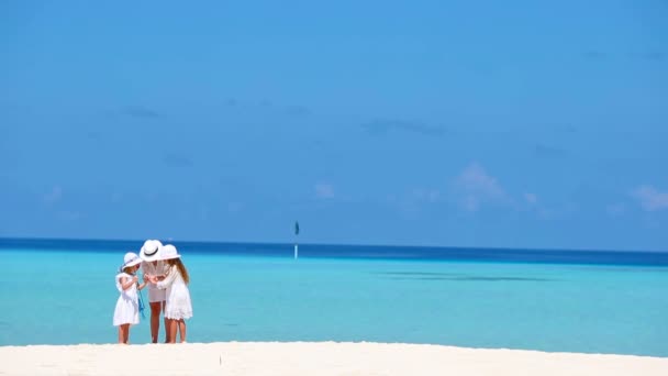 Beyaz elbiseli ailenin yaz tatilinin tadını çıkardığı güzel bir tropikal plaj manzarası. — Stok video