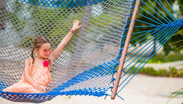Adorable niña balanceándose en hamaca en la playa —  Fotos de Stock
