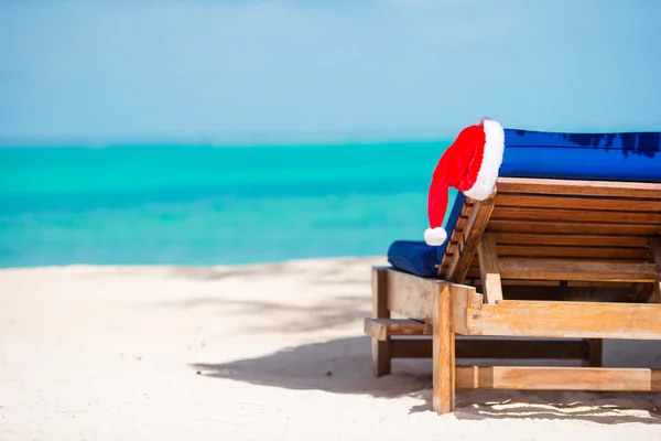 Ξαπλώστρα με Santa καπέλο στην πανέμορφη τροπική παραλία με λευκή άμμο και τιρκουάζ νερά — Φωτογραφία Αρχείου
