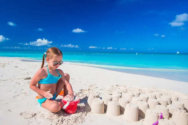 Bambino che gioca con i giocattoli della spiaggia sulla spiaggia bianca — Foto Stock