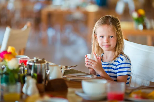 Imádnivaló kislány reggelizik a szabadtéri kávézóban — Stock Fotó