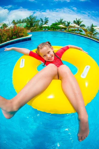 Kleines Mädchen hat Spaß im aufblasbaren Gummikreis am Schwimmbad. Sommerurlaub für die Familie, Kind entspannen am Pool. — Stockfoto