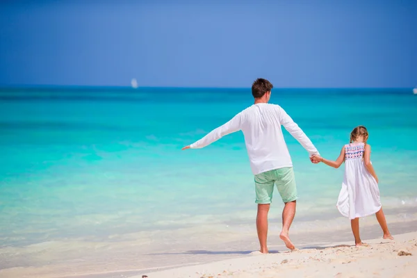 Feliz padre y su adorable hijita en la playa tropical. Familia caucásica divirtiéndose juntos en vacaciones suumer en la playa blanca corriendo y disfrutando de sus vacaciones —  Fotos de Stock