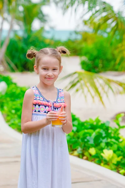 Adorable niña con jugo de naranja en la cafetería al aire libre —  Fotos de Stock
