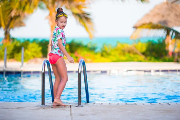 Pequena menina adorável feliz na piscina exterior. Menina adolescente bonita desfrutar de natação na piscina no hotel exótico tropical ao ar livre . — Fotografia de Stock