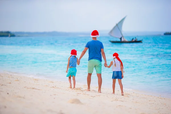 Glückliche Familie in Weihnachtsmützen im Sommerurlaub. Weihnachtsurlaub mit vierköpfiger Familie, die ihre Seereise genießt — Stockfoto