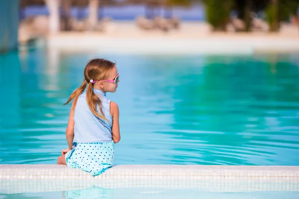 Little happy adorable girl in outdoor swimming pool. Beautiful teenager girl enjoy vacation at tropical exotic hotel outdoors. — Stock Photo, Image