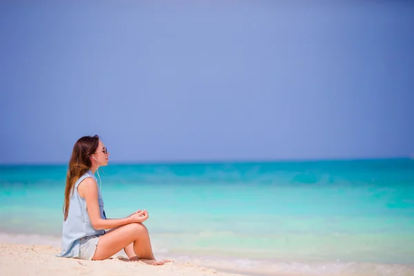 Krásná žena v meditaci na pláži. Šťastná dívka v relaxační pozice jógy na tropické pláži — Stock fotografie