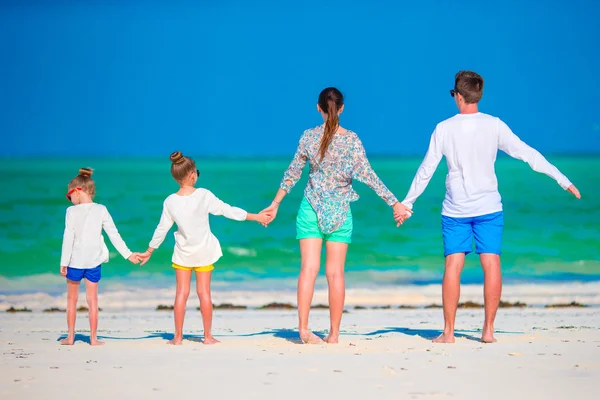 Mladá rodina na dovolenou. Šťastný otec, matka a jejich aktivní děti baví na jejich letní dovolenou u moře — Stock fotografie