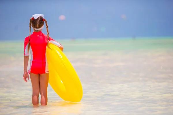 Beach tatil sırasında şişme lastik daire ile sevimli küçük kız. Çocuk yaz etkin tatile eğleniyor — Stok fotoğraf