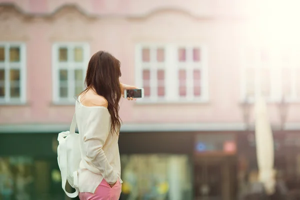ヨーロッパの都市でセルフ ポートレートを取る若い女性。白人観光客がプラハで彼女のヨーロッパの夏の休暇を楽しむ — ストック写真