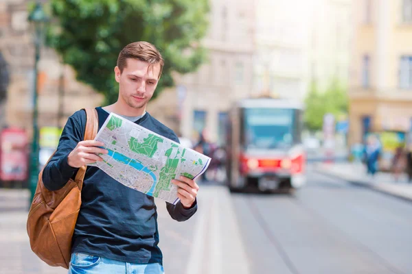 在城市地图与在欧洲背包墨镜的年轻男子。看看这个地图欧洲城市寻找景点的白种人旅游. — 图库照片