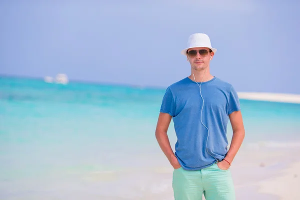 Unge man på strandsemester. Glad pojke njuta av stranden och varmt väder medan promenader längs havet — Stockfoto