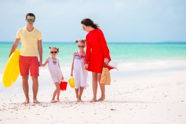 Genç ailesi tatilde. Mutlu baba, anne ve sevimli çocukları yaz plaj tatillerini eğleniyor