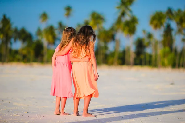 Pequenas meninas caucasianas na praia durante as férias de verão. Crianças felizes se divertindo juntas em suas férias de verão em família . — Fotografia de Stock