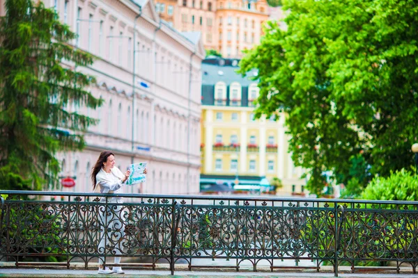 Happy young woman with a city map in Europe. Travel tourist woman with map in Prague outdoors during holidays in Europe. — Stock Photo, Image