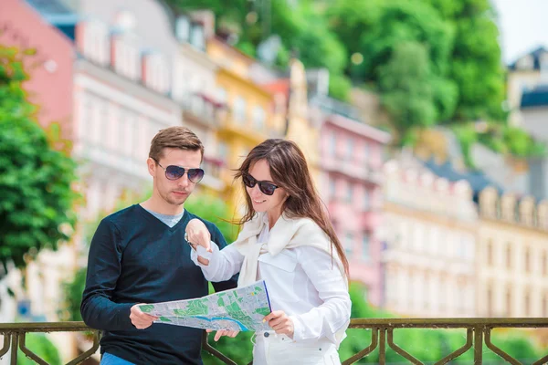 Młoda para turystów podróżująca na wakacje w Europie uśmiechnięta szczęśliwa. Kaukaska rodzina z mapą miasta w poszukiwaniu atrakcji — Zdjęcie stockowe