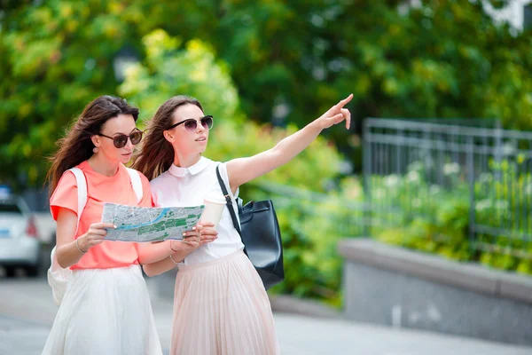 Gelukkig jonge vrouwen met boodschappentassen wandelen langs stad straat. Verkoop, consumentisme en mensen concept. — Stockfoto