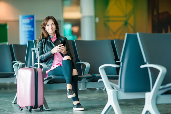 Passageiro da companhia aérea em um lounge do aeroporto esperando por aeronaves de voo. Mulher branca com smartphone na sala de espera — Fotografia de Stock