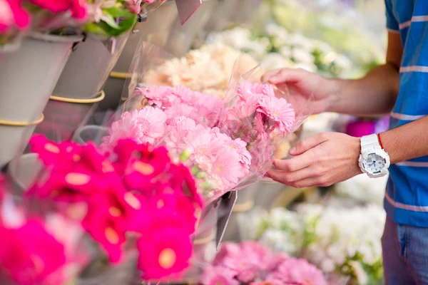 Young man selecting fresh flowers to his lovely girlfriend at european market. Closeup variety and vibrant flowers. — Stock Photo, Image