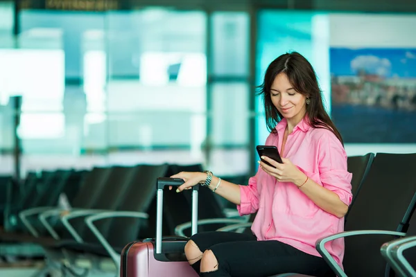 Passageiro da companhia aérea em um lounge do aeroporto esperando por aeronaves de voo. Mulher branca com smartphone na sala de espera — Fotografia de Stock