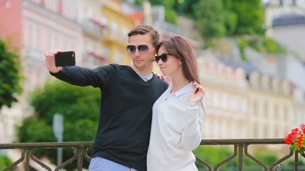 Selfie Foto: Kavkazský pár cestování v Evropě. Romantické cestování žena a muž v lásku usmívající se šťastný užívání autoportrét venkovní během dovolené dovolená v Praze — Stock video
