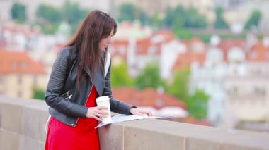 Avrupa 'da kahve içen mutlu genç şehir kadını. Avrupa 'da tatillerde sıcak içeceklerle gezen bir turist kadın..