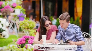 Restoran turistleri açık kafede yemek yiyorlar. Genç kadın ve erkek sıcak yaz gününün tadını çıkarıyorlar.