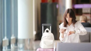 Havaalanı lobisindeki yolcu uçuş için bekliyor. Beyaz kadın bekleme odasında zaman geçirmek istiyor.