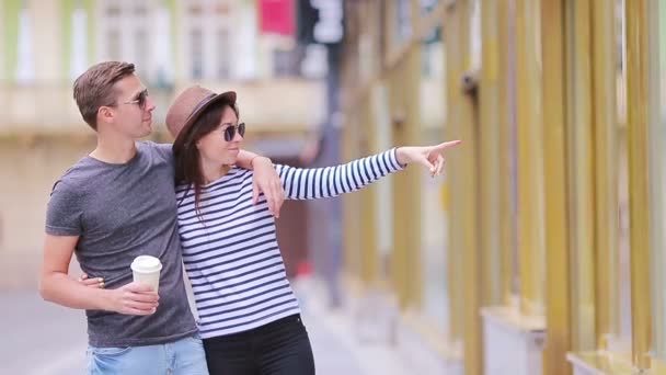 Romantiska par promenader tillsammans i Europa. Lycklig älskare njuter av stadsbilden med berömda landmärken. Eleganta urbana ung man med varmt kaffe och kvinnan i hatten på resor i Prag — Stockvideo