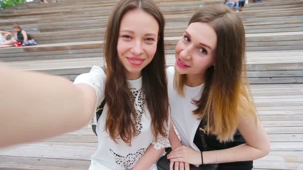 Όμορφες χαρούμενες κοπέλες χαμογελούν και φτιάχνουν selfie. Νέοι τουριστικοί φίλοι ταξιδεύουν σε διακοπές σε εξωτερικούς χώρους χαμογελαστός. — Αρχείο Βίντεο