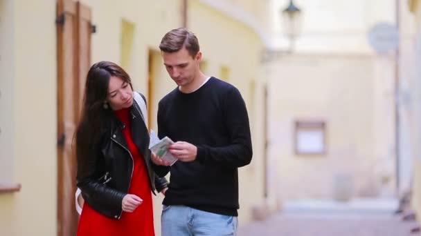 Feliz casal turístico viajando em férias na Europa sorrindo feliz. Casal caucasiano com mapa da cidade ao ar livre — Vídeo de Stock