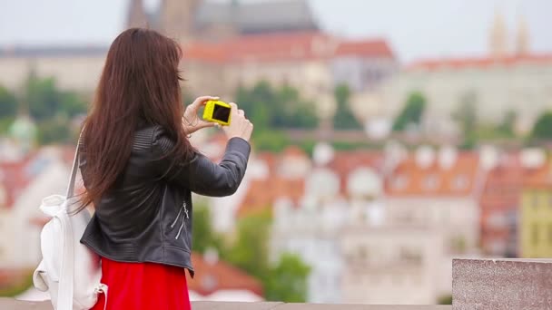 夏休みはスマートフォンで有名なアトラクションで旅行写真を撮る観光客の女の子。休日の旅行先を楽しんで屋外で携帯電話で写真を撮る若い魅力的な観光客 — ストック動画